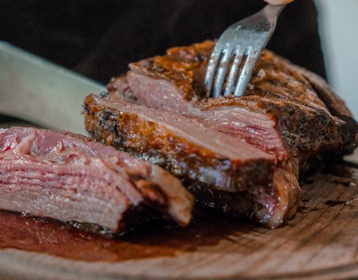 person slicing cooked meat