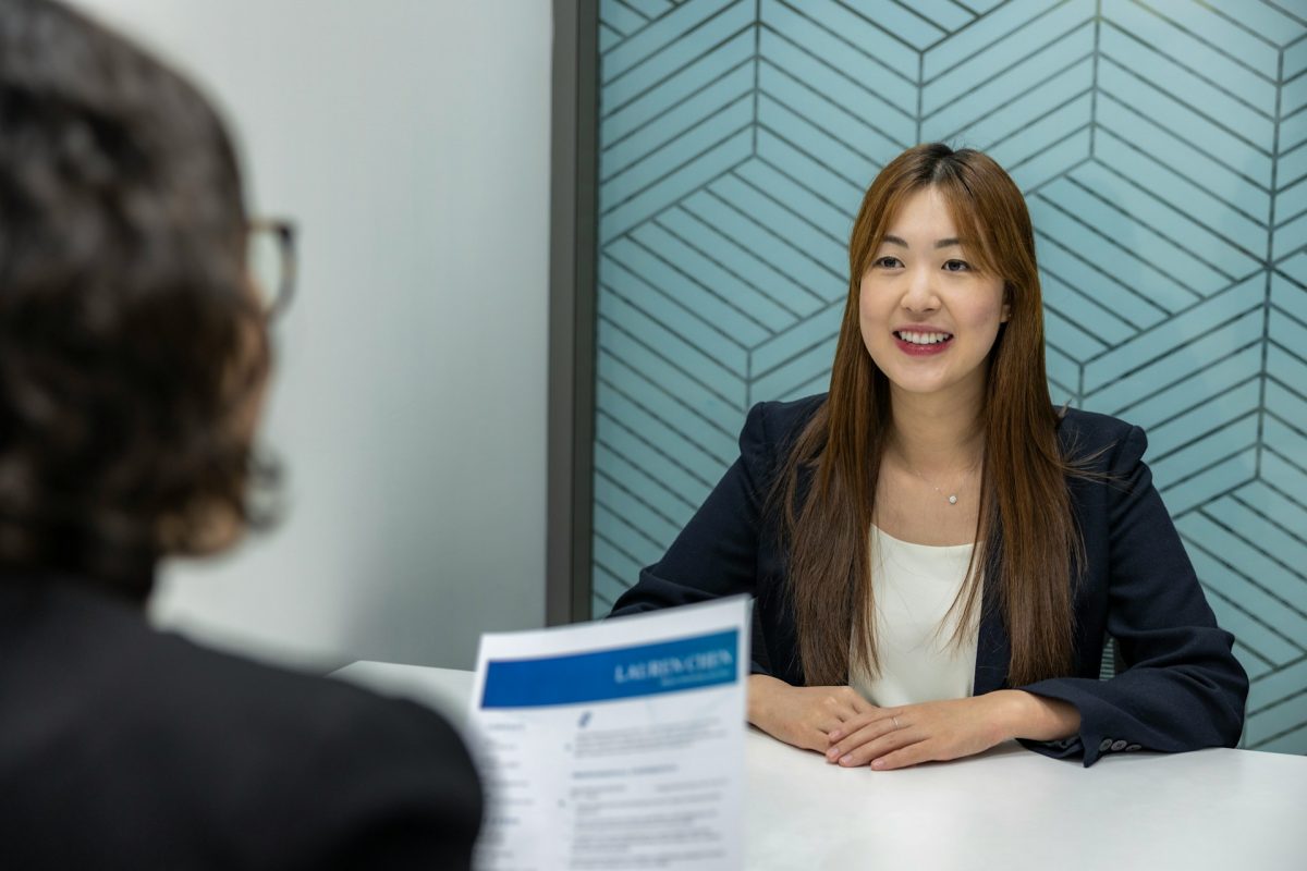 a-woman-sitting-at-a-table-with-a-piece-of-paper-in-front-of-her