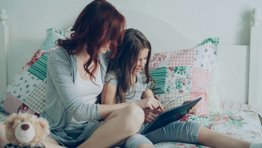 mom-and-daughter-read-on-a-tablet-together