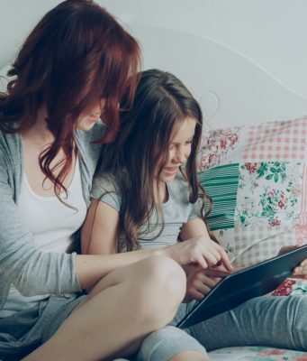 mom-and-daughter-read-on-a-tablet-together